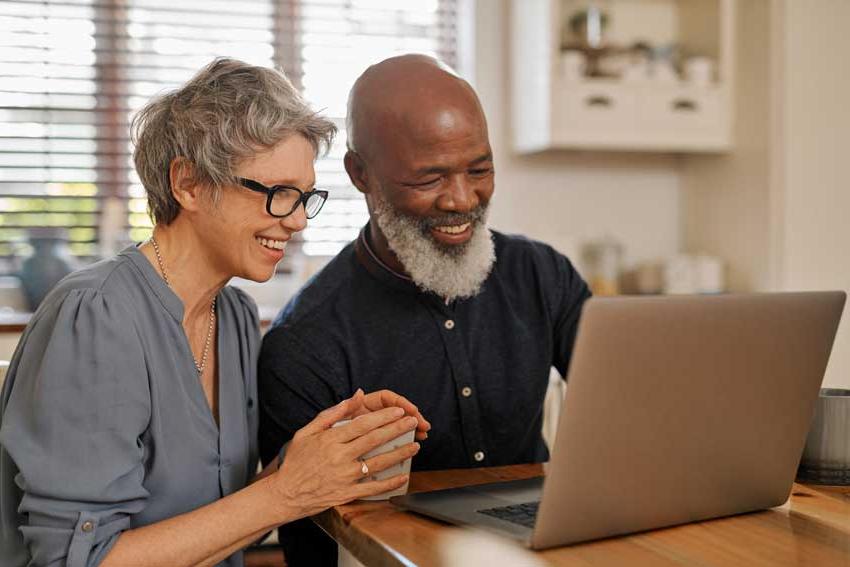 微笑的老夫妇看着笔记本电脑